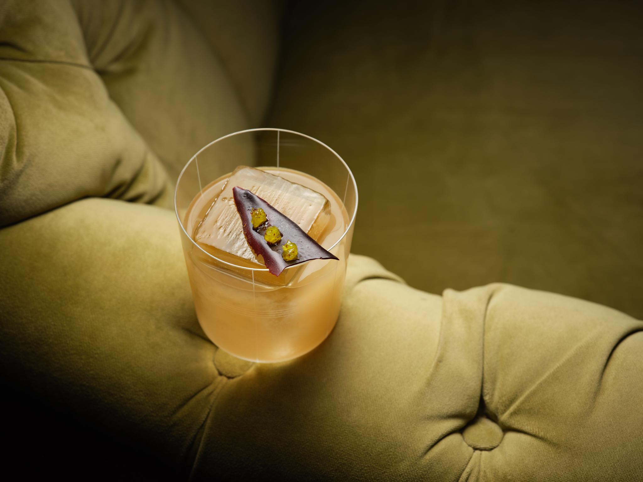 Glass of drink on arm of sofa